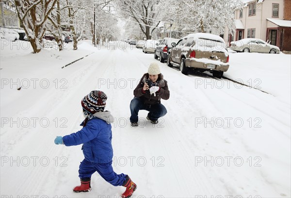 Caucasian mother and son playing in snow