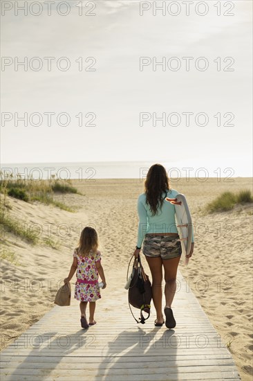 Mother and daughter walking on beach