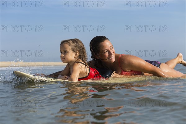 Mother and daughter surfing