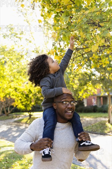 Father carrying son on shoulders outdoors