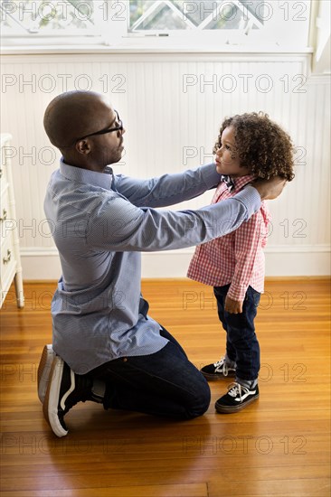 Father adjusting collar for son