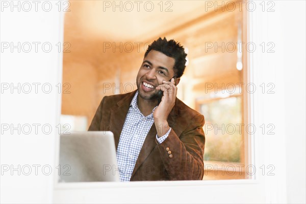 African American businessman talking on cell phone in office
