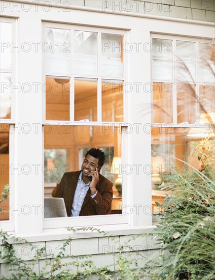 African American businessman talking on cell phone in office