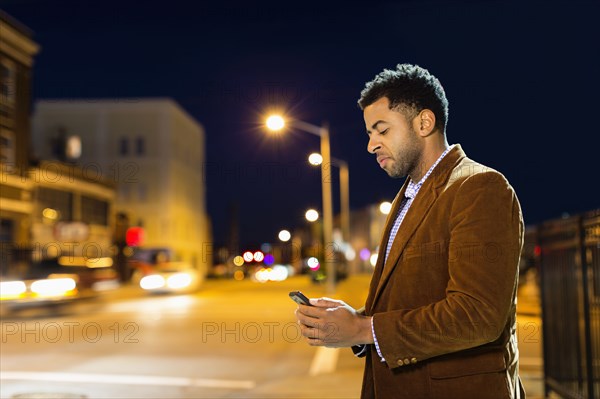 African American businessman using cell phone outdoors