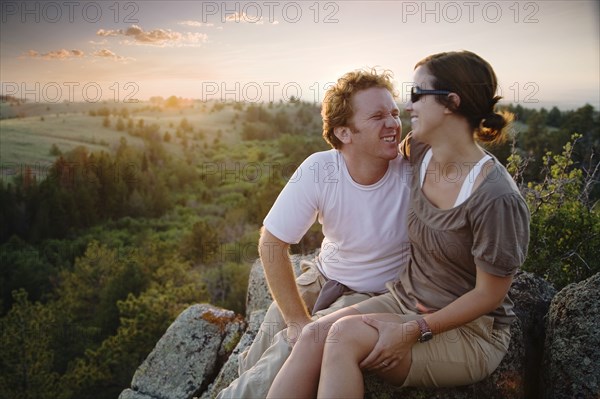 Caucasian couple hugging on remote hilltop