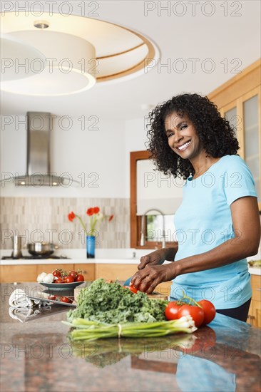 Black woman chopping vegetables in kitchen