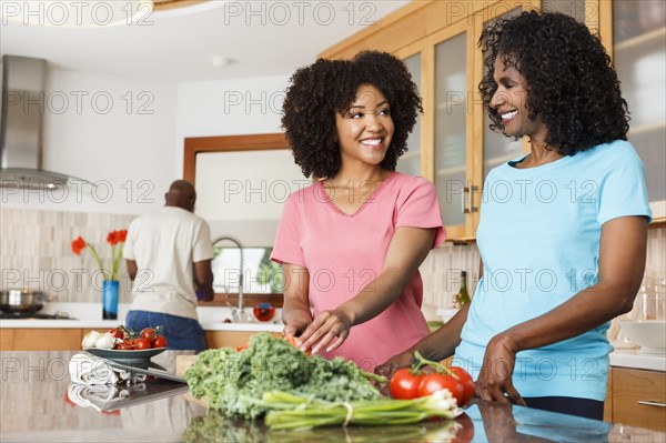 Black women chopping vegetables in kitchen