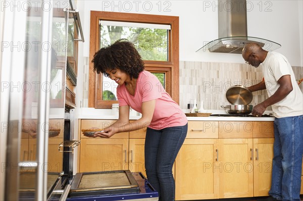 Black father and daughter cooking in kitchen