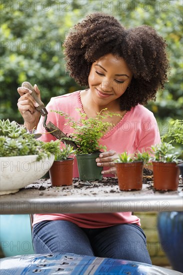 Black woman gardening at table outdoors