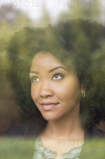 Pensive Black woman behind window