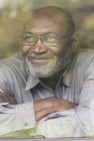 Smiling Black man behind window