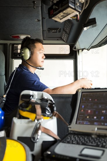 Chinese fireman wearing headphones driving fire truck