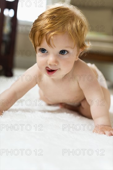 Caucasian baby boy crawling on carpet