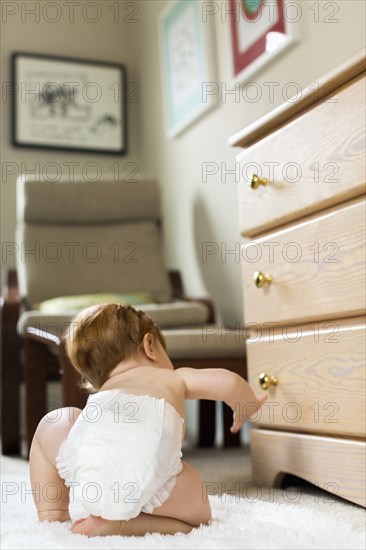 Caucasian baby boy crawling on carpet