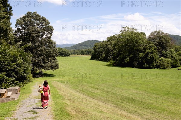 Caucasian mother carrying son in park