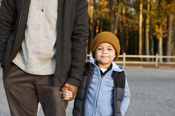 Father and son holding hands in park