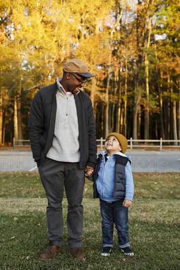 Father and son holding hands in park