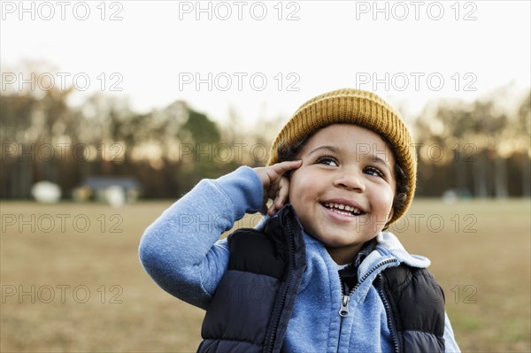 Mixed Race boy gesturing telephone in park