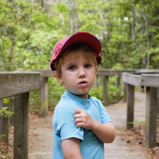 Caucasian boy scratching shoulder in park