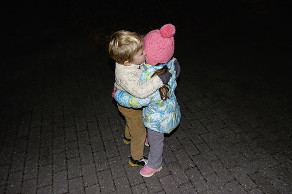 Boy ad girl hugging outdoors at night