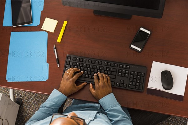 African American man typing on computer keyboard in office