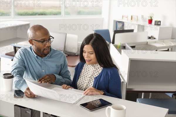 Man and woman reading paperwork in office