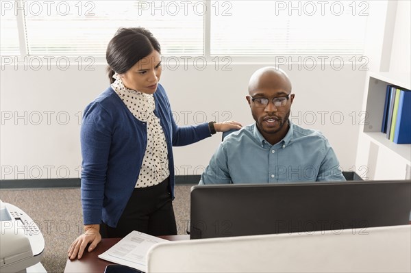 Man and woman working at computer in office