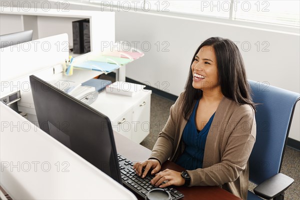 Pacific Islander woman using computer in office