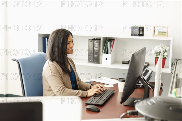 Pacific Islander woman using computer in office