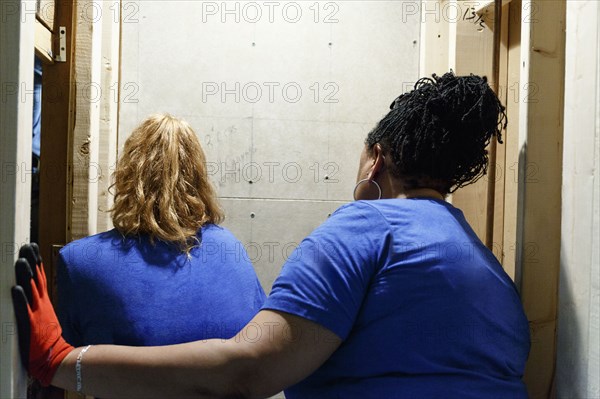 Women examining wall