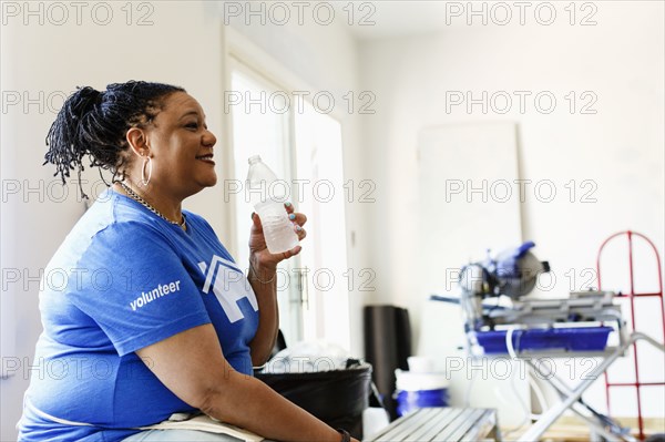 Black volunteer woman drinking water