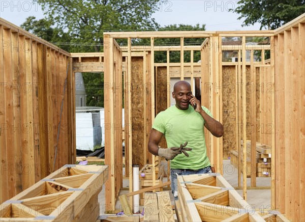 Volunteer building house talking on cell phone