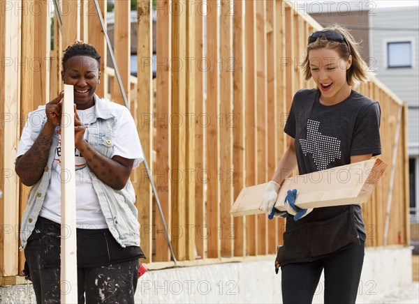 Volunteers carrying lumber at a construction site