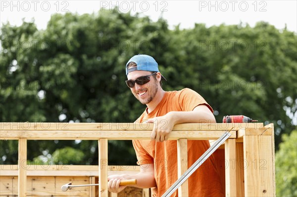 Caucasian man hammering at construction site