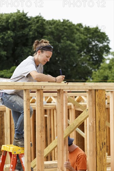 Caucasian woman measuring at construction site