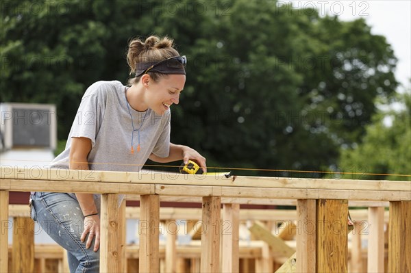 Caucasian woman measuring at construction site