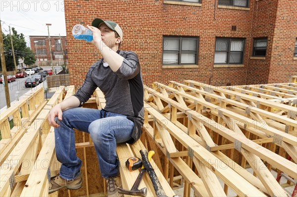 Caucasian man drinking beverage at construction site