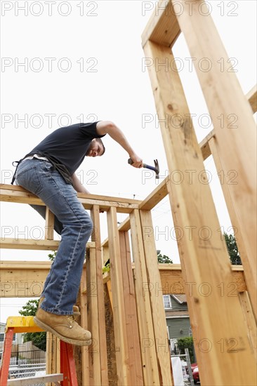 Caucasian man hammering nail at construction site