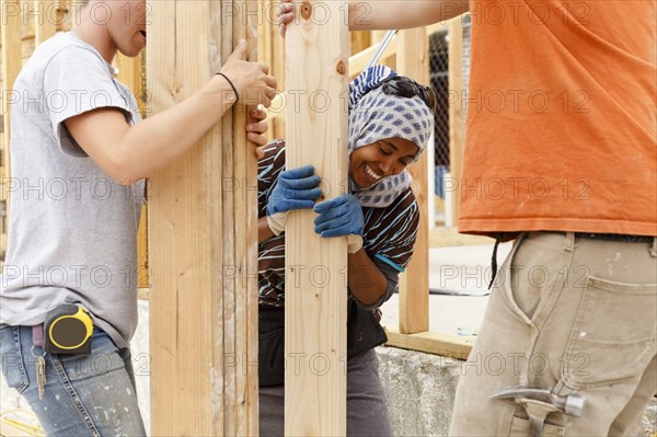 Volunteers holding lumber at construction site