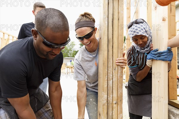 Volunteers holding lumber at construction site