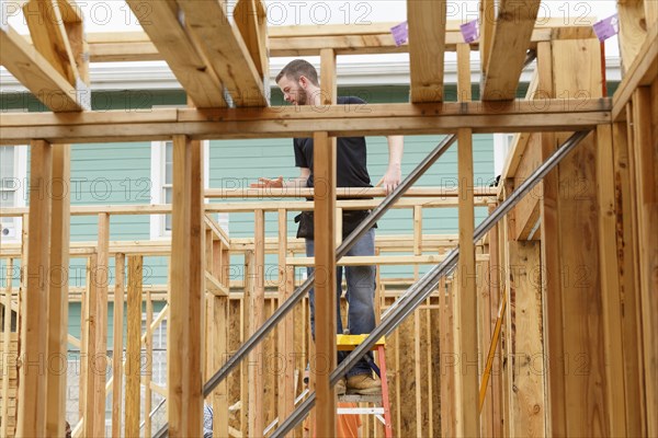 Caucasian man standing on ladder at construction site