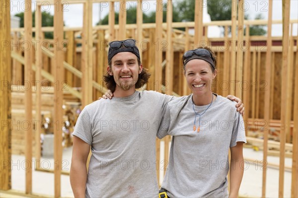 Caucasian man and woman posing at construction site