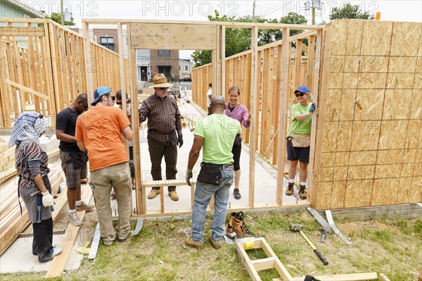 Volunteers holding wall at construction site