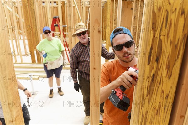 Volunteer using drill at construction site