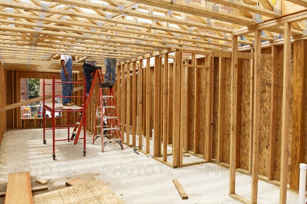 Volunteers standing on ladders and scaffolding at construction site