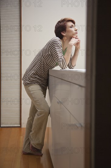 Woman leaning on kitchen counter