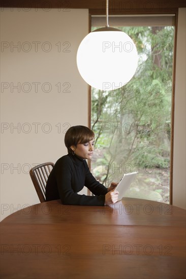 Caucasian woman using tablet computer at table