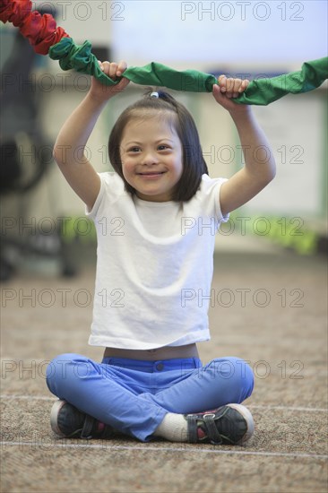 Mixed race Down syndrome girl playing with rope