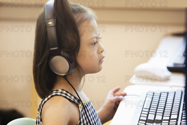 Mixed race Down syndrome student using computer