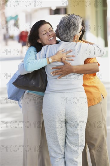 Three women hugging outdoors